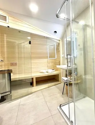 a glass shower in a bathroom with a table at STUDIO KRÁLOVICE Apartment in Prague
