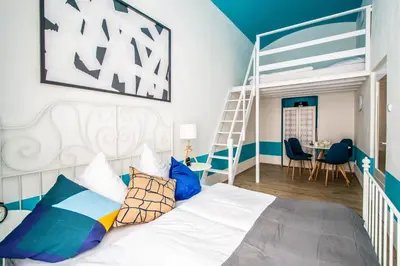 a bedroom with a bed with a ladder and a table at Sweet Home by Ruterra in Prague