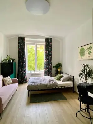 a bedroom with a bed and a window at Cute botanical flat near by Žižkov tower in Prague
