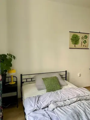 a bedroom with a bed with a green pillow on it at Cute botanical flat near by Žižkov tower in Prague