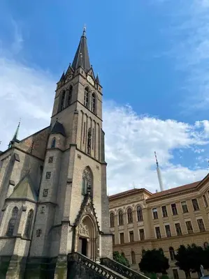 a church with a tower on top of a building at Cute botanical flat near by Žižkov tower in Prague