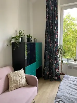 a living room with a couch and a dresser and a window at Cute botanical flat near by Žižkov tower in Prague