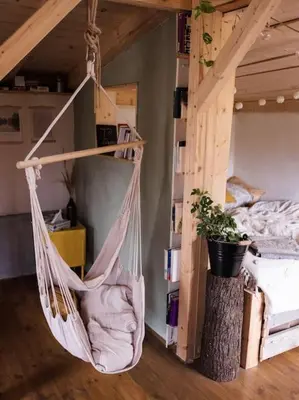 a hammock hanging in a room with a bed at Sušárna v zahradě s vůní bylinek in Křivoklát