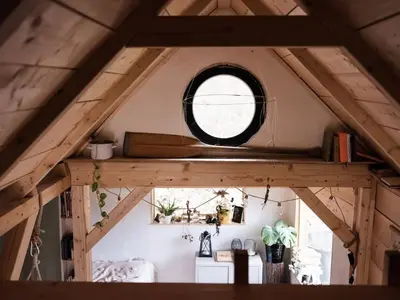 a room with a round window in a attic at Sušárna v zahradě s vůní bylinek in Křivoklát