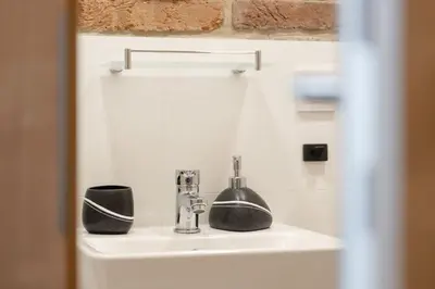 a sink with a faucet and two cups on it at Mezzanine Beds, 10min to Centre with Offsite Parking in Prague