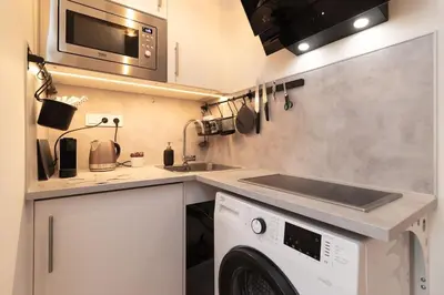 a kitchen with a washing machine and a microwave at Mezzanine Beds, 10min to Centre with Offsite Parking in Prague