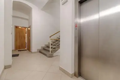 a hallway with a door and stairs in a building at Mezzanine Beds, 10min to Centre with Offsite Parking in Prague