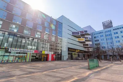 an empty street in a city with tall buildings at Mezzanine Beds, 10min to Centre with Offsite Parking in Prague