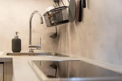 a kitchen with a sink and a basket on the wall at Mezzanine Beds, 10min to Centre with Offsite Parking in Prague