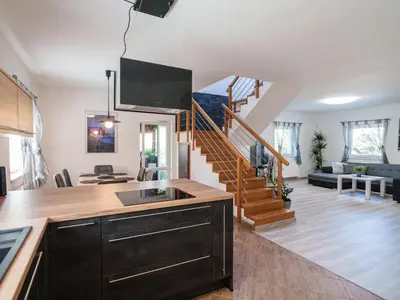 a kitchen and living room with a spiral staircase at Holiday Home Starý Chodov by Interhome in Prague