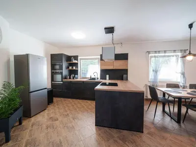 a kitchen with a refrigerator and a table with chairs at Holiday Home Starý Chodov by Interhome in Prague