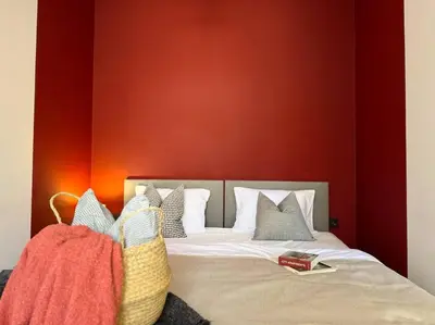 a bedroom with a bed with a red wall at Red Currant - Prague Apartment in Prague