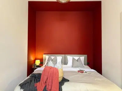 a bedroom with a bed with a red wall at Red Currant - Prague Apartment in Prague