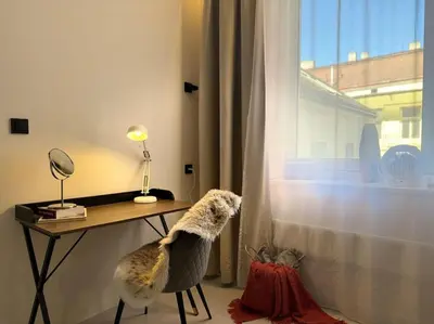 a dog sitting at a desk looking out the window at Red Currant - Prague Apartment in Prague