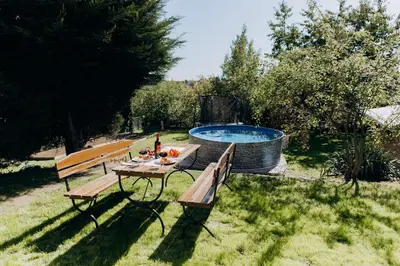 a picnic table and two benches next to a pool at DiamondVilla, 4 bedroom Apartment, garden & spa in Prague