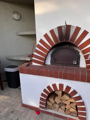 a brick pizza oven with a pile of wood at DiamondVilla, 4 bedroom Apartment, garden & spa in Prague