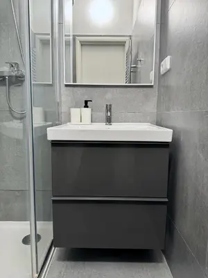 a bathroom with a sink and a mirror and a shower at Apartment by Charles Bridge in Prague
