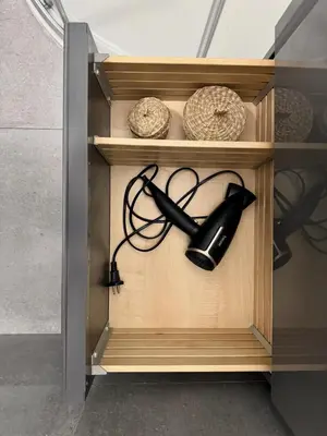a cabinet with a hair dryer and other items in it at Apartment by Charles Bridge in Prague