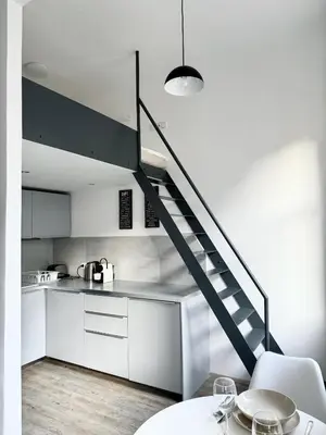 a kitchen with white cabinets and a staircase at Apartment by Charles Bridge in Prague