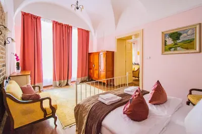 a bedroom with a bed and a chair in a room at Astronomical Clock Suite by Ruterra in Prague