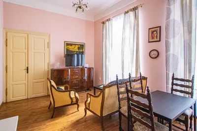 a dining room with a table and chairs and a television at Astronomical Clock Suite by Ruterra in Prague