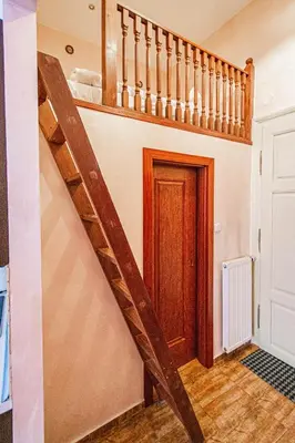 a wooden staircase in a room with a door at Astronomical Clock Suite by Ruterra in Prague