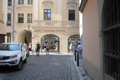 a group of people walking on a street in front of a store at Astronomical Clock Suite by Ruterra in Prague