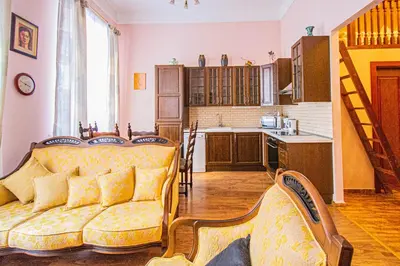 a living room with a couch and a kitchen at Astronomical Clock Suite by Ruterra in Prague