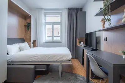 a hotel room with a bed and a desk and a desk at City Pop 2Night Prague - Self check-in in Prague