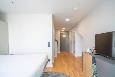 a white living room with a bed and a large window at City Pop 2Night Prague - Self check-in in Prague
