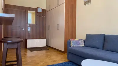 a living room with a blue couch and a table at Apartmán v centru Prahy in Prague