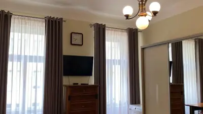 a bedroom with curtains and a television and a dresser at Apartmán v centru Prahy in Prague