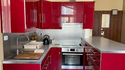 a kitchen with red cabinets and a sink at Apartmán v centru Prahy in Prague