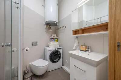 a kitchen and dining room with a table and a door at Seifertova Apartments by Willstay in Prague
