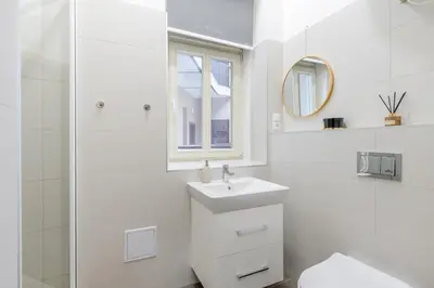 a bedroom with a bed and a couch and a window at Seifertova Apartments by Willstay in Prague