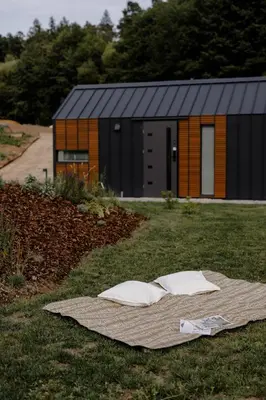 a house with two pillows on a blanket in the grass at Glamping Osada in Hyskow