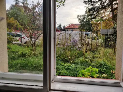 a small kitchen with a counter and a room with a bed at Apartment in house with private parking and garden in Prague