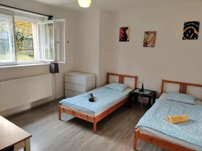 a bedroom with two beds and a window at Apartment in house with private parking and garden in Prague