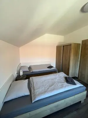 two twin beds in a room with wooden cabinets at Penzion Kopanský mlýn in Statenice