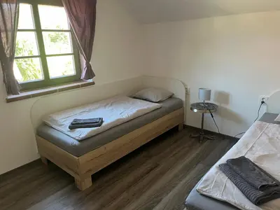 a small bedroom with a bed and a window at Penzion Kopanský mlýn in Statenice