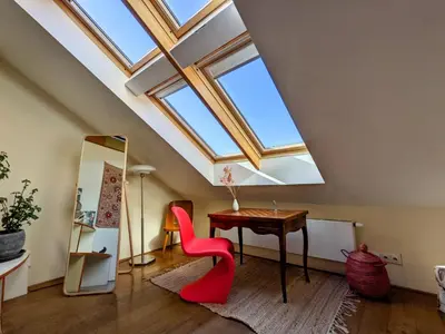 an attic room with a desk and a skylight at Guestrooms, rooftop with garden, spacious living room, character and fireplace in Prague
