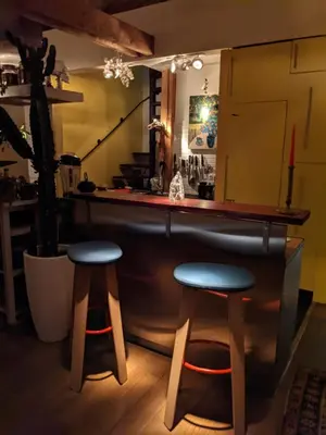 a bar with two stools in front of a counter at Guestrooms, rooftop with garden, spacious living room, character and fireplace in Prague