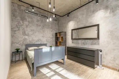 a bedroom with a bed and a mirror on a wall at LOFT Apartments in Prague