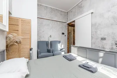 a bedroom with a bed and a blue chair at LOFT Apartments in Prague