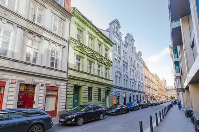 a row of cars parked on a street with buildings at LOFT Apartments in Prague