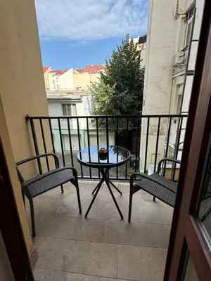 a patio with a table and two chairs on a balcony at Cool Vitkova apartment with balcony in Prague