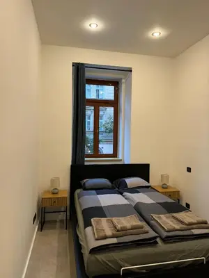 a bedroom with a bed and a window at Cool Vitkova apartment with balcony in Prague