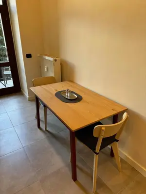 a wooden table and a chair in a room at Cool Vitkova apartment with balcony in Prague