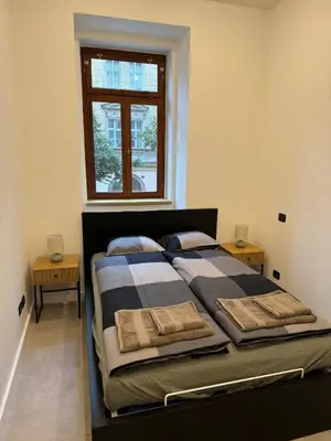 a bedroom with a bed with two pillows and a window at 1 Bed Flat - Sleeps 2 - Pets - Smoking on terrace in Prague