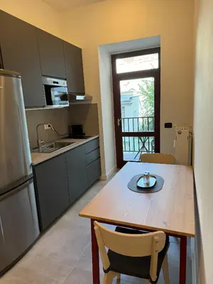 a kitchen with a wooden table and a kitchen with a sink at 1 Bed Flat - Sleeps 2 - Pets - Smoking on terrace in Prague
